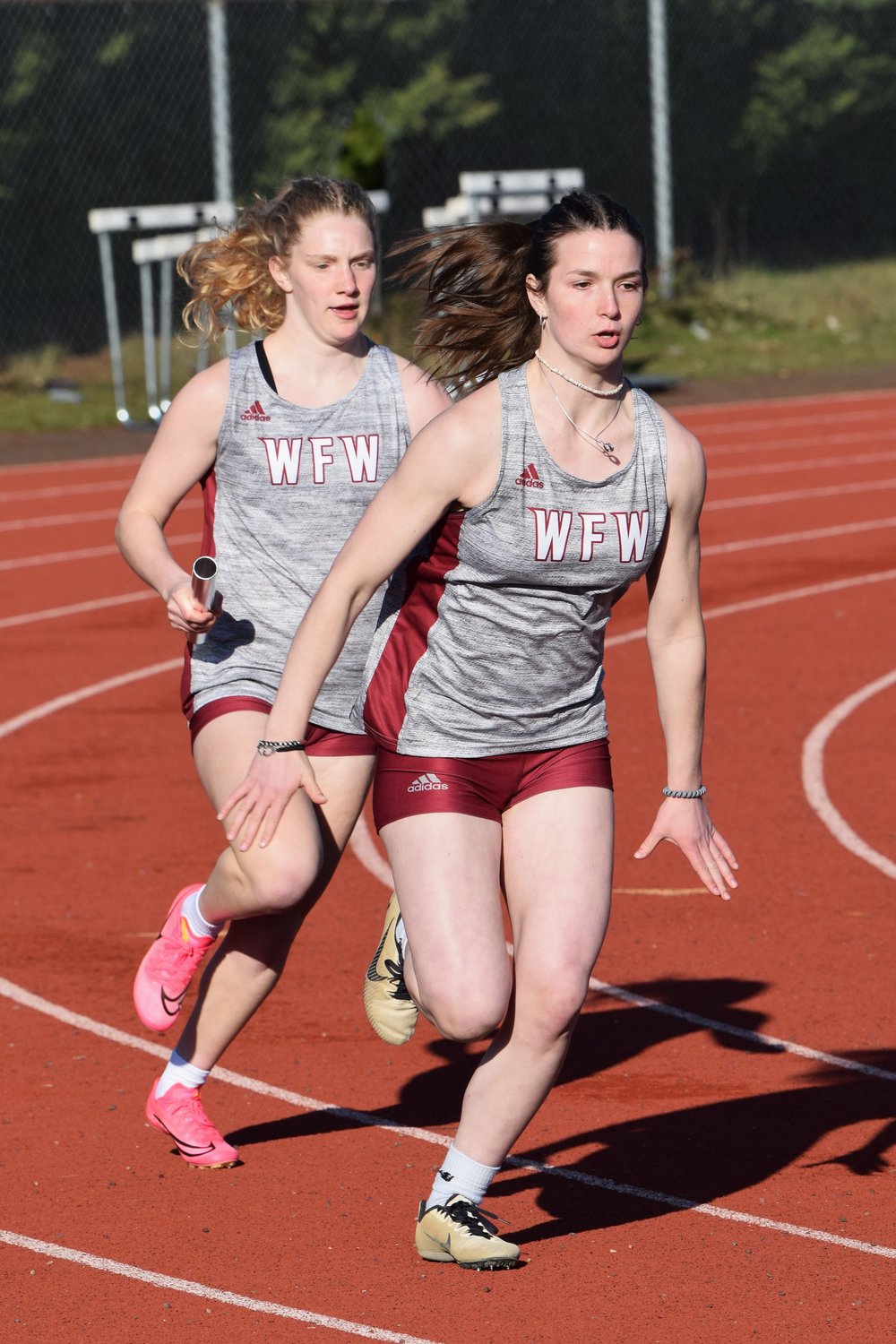 Emily Mallonee hands the baton off to Amanda Bennett during a relay at W.F. West's dual meet at Tumwater on March 21.